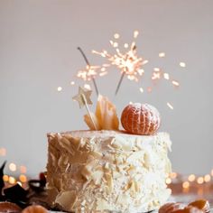 a white cake topped with frosting and sprinkles on top of a table