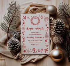 a christmas card surrounded by pine cones, ornaments and other holiday decorations on a blanket