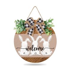 a welcome sign hanging from the side of a wooden plaque with two rabbits on it