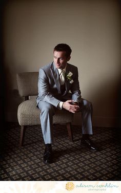 a man in a suit sitting on a chair