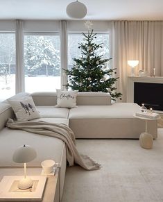 a living room filled with furniture and a christmas tree in the middle of the room