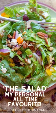 a salad with lettuce, cranberries and pecans on the side