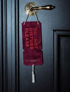 a door handle with a red sign hanging from it's side on a black door