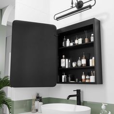 a bathroom sink sitting under a mirror next to a black cabinet