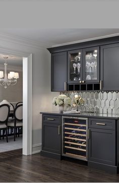 a dining room table with wine glasses on it and an empty glass cabinet in the middle