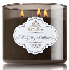 a candle that is sitting in front of a white background with the words mahogany teakwood on it