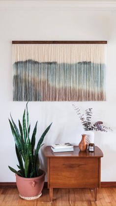 a living room with a wooden table and potted plant