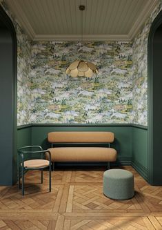 a room with green walls and wooden flooring, two chairs and a couch in the corner