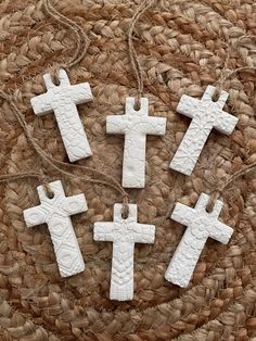 four white ceramic crosses on a woven mat