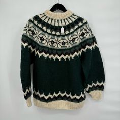 a green and white sweater hanging on a hanger