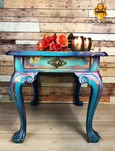 a blue painted table with flowers on top