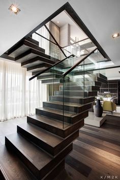 an open staircase with glass railings and wooden steps leading up to the second floor