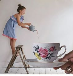 a woman pouring water into a teacup on top of a table next to a stepladder