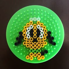 a green plate topped with lots of black and yellow beads