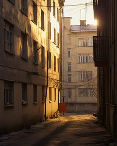 the sun is shining down on an alley way with apartment buildings in the background,