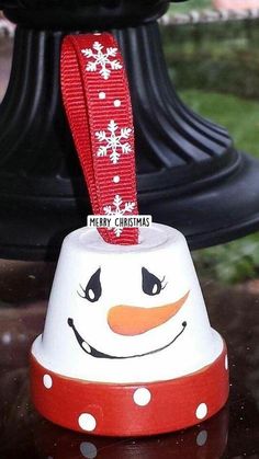 a snowman bell ornament with a red ribbon