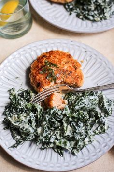 two white plates topped with food and a fork