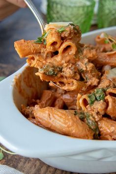 a white bowl filled with pasta and meat