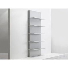 a white book shelf sitting next to a wall