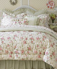 a bed with floral comforter and pillows