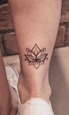 a woman's foot with a lotus tattoo on the left side of her leg