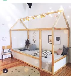 a child's bedroom with a bed made out of wood and white walls, wooden flooring