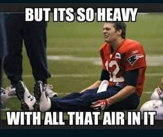 a football player sitting on the ground with his foot up and another person standing behind him