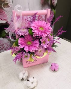 a pink box with purple flowers in it on a table