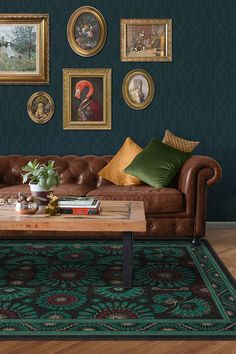 a living room with green walls and pictures on the wall above the couch, along with a coffee table