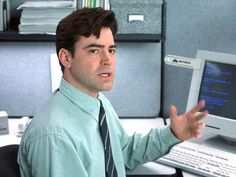 a man in a shirt and tie holding his hands out to someone on a computer