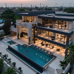 an aerial view of a modern house with pool in the foreground and surrounding buildings