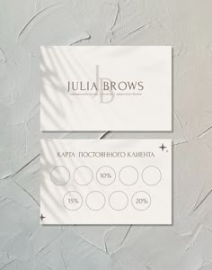 two business cards with the name julia brown's on them are displayed against a white wall