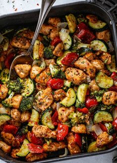 a pan filled with chicken, broccoli and peppers