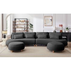 a living room with a large sectional couch and ottoman in grey fabric on the floor