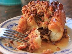 a piece of bread pudding on a blue and white plate with a fork in it