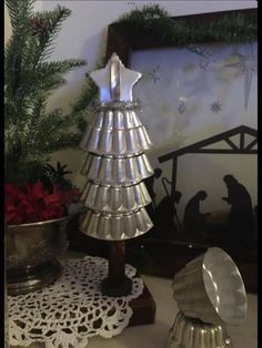 a christmas tree made out of tinsel next to other holiday decorations on a table