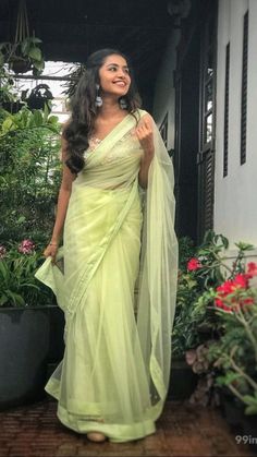 a woman in a yellow sari posing for the camera