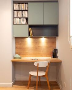 a small desk with a chair and bookshelf in the corner next to it