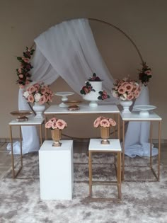 a table set up with flowers and vases on it