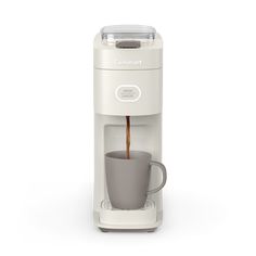 a white coffee maker with a cup in it