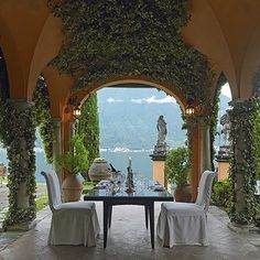 an outdoor dining area with two chairs and a table