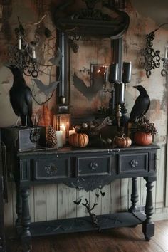 a black table with candles and pumpkins on it in front of a large mirror