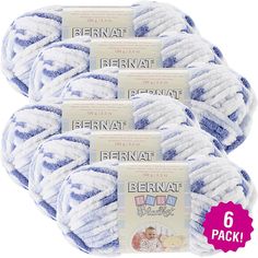 four balls of bernat baby yarn in blue and white, with the label on each ball