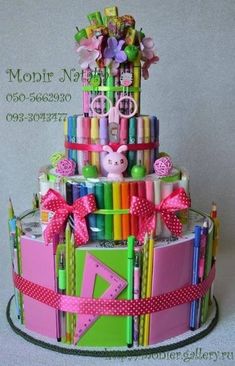 a multi - tiered cake made out of crayons and colored pencils