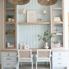 two wicker chairs sit at a table in front of a built - in hutch