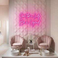 two pink chairs in front of a wall that says don't be a lady be a legend