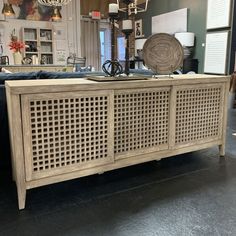 a large wooden cabinet with an intricate design on the front and side panels, in a store