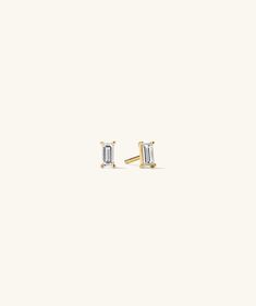 two diamond stud earrings in yellow gold, set on a plain white background with the back facing