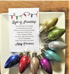 a christmas ornament on a plate with a card in front of it that says light of friendship