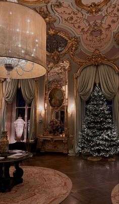 a living room with a christmas tree in the center and chandelier hanging from the ceiling